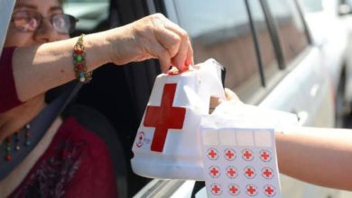 Mujer cooperando desde su vehículo para la colecta de la Cruz Roja