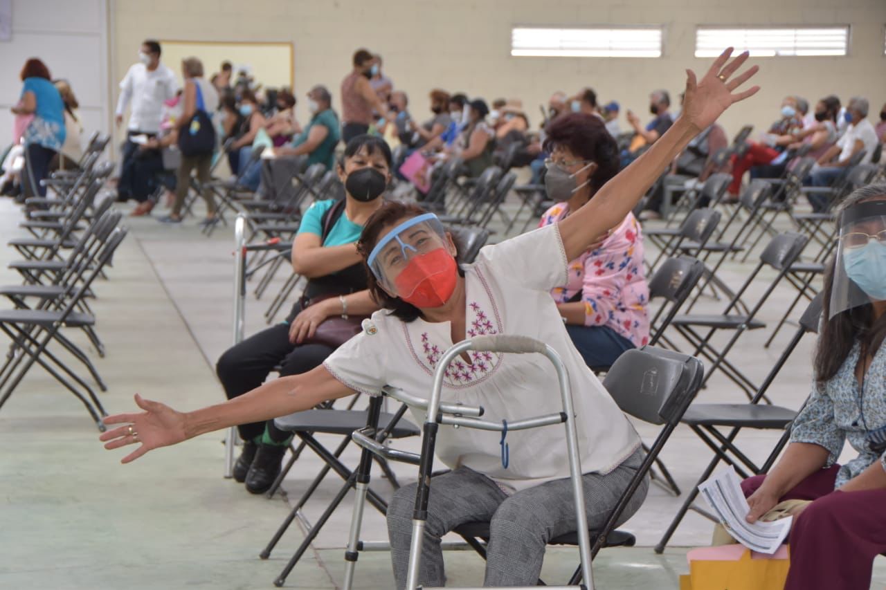 mujer usando muletas, feliz por recibir vacuna contra covid-19 en el Estado de México