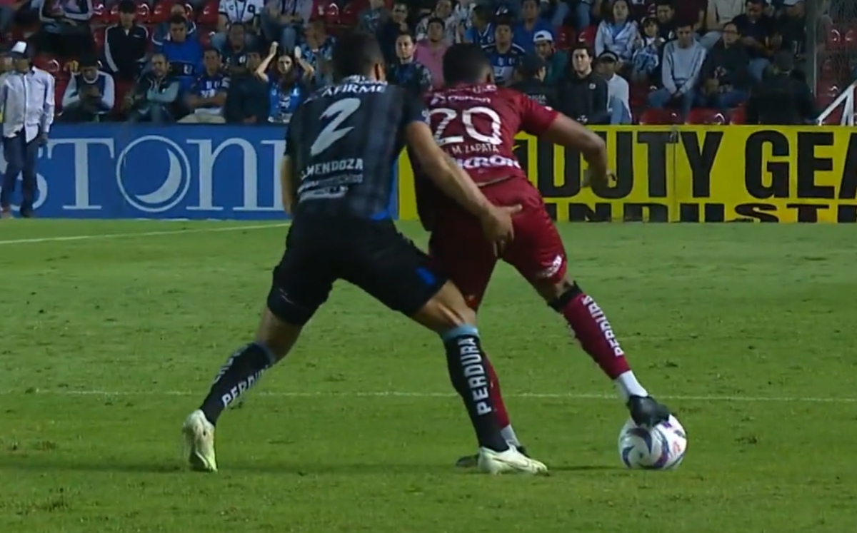 Foto de Omar Mendoza mientras toca a Juan Zapara en el Querétaro vs Atlas de la Liga MX.