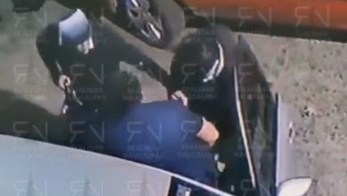 En un video captado por una cámara de seguridad, se puede ver a un sujeto con chamarra oscura, gorro, pantalón de mezclilla y cubrebocas abrir la puerta de un taxi que se encontraba estacionado. Foto: Captura